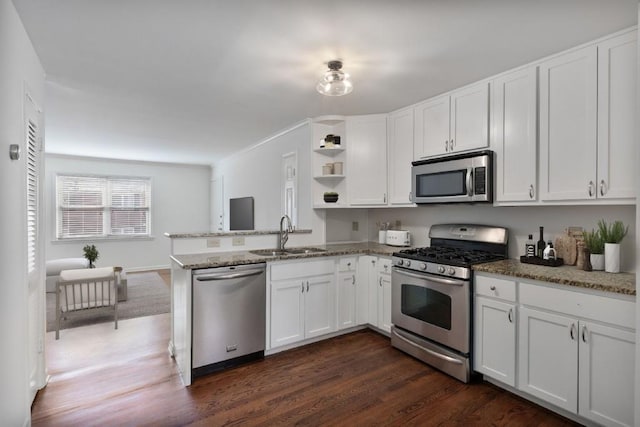 kitchen featuring white cabinetry, sink, light stone counters, and appliances with stainless steel finishes