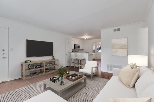 living room featuring ornamental molding and wood-type flooring