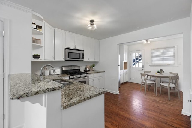 kitchen featuring dark wood-type flooring, sink, stone counters, stainless steel appliances, and white cabinets