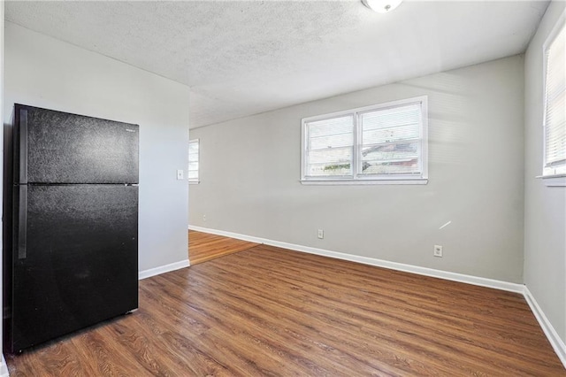 spare room featuring a textured ceiling and hardwood / wood-style floors