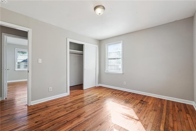 unfurnished bedroom with a closet and wood-type flooring