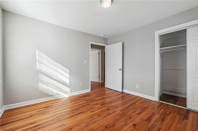 unfurnished bedroom featuring a closet and hardwood / wood-style flooring