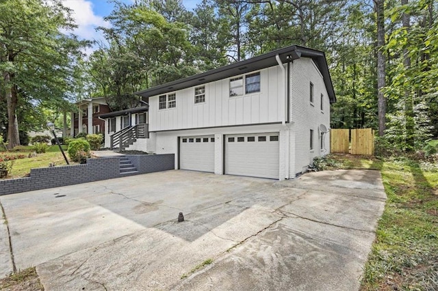 4760 Silverdale Rd, College Park, GA 30349 - view of front of house with concrete driveway, board and batten siding, an attached garage, and brick siding