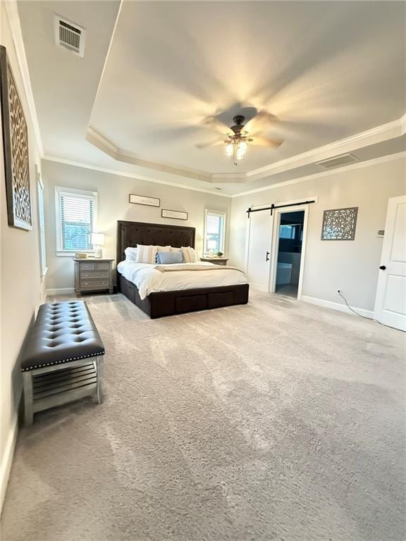 bedroom with ornamental molding, a raised ceiling, carpet floors, ceiling fan, and a barn door