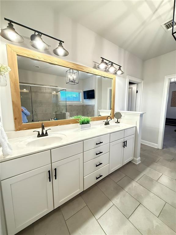 bathroom featuring a shower with door, vanity, and tile patterned floors