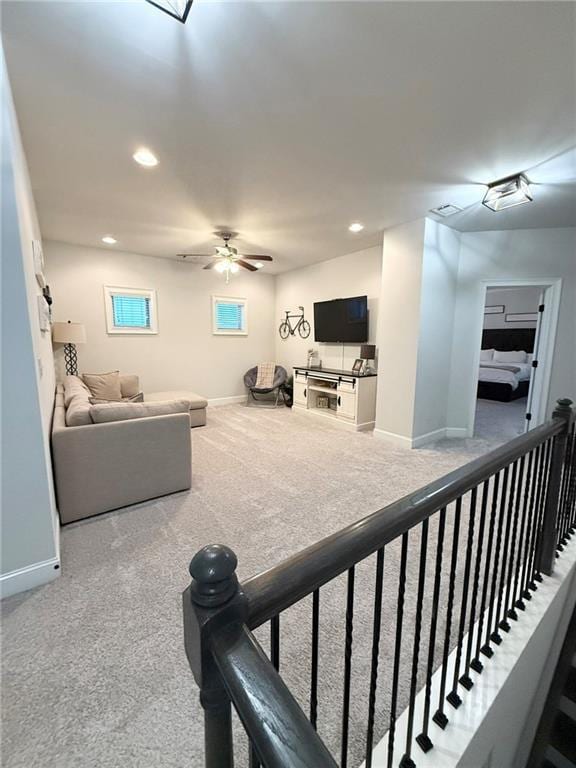 carpeted living room with ceiling fan