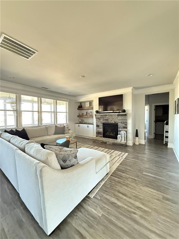 living room with crown molding, dark hardwood / wood-style floors, and a fireplace