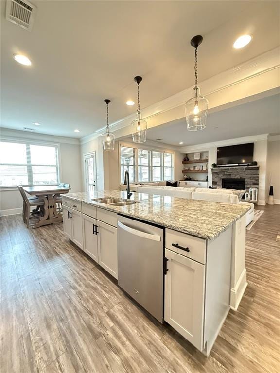 kitchen featuring pendant lighting, sink, stainless steel dishwasher, and white cabinets