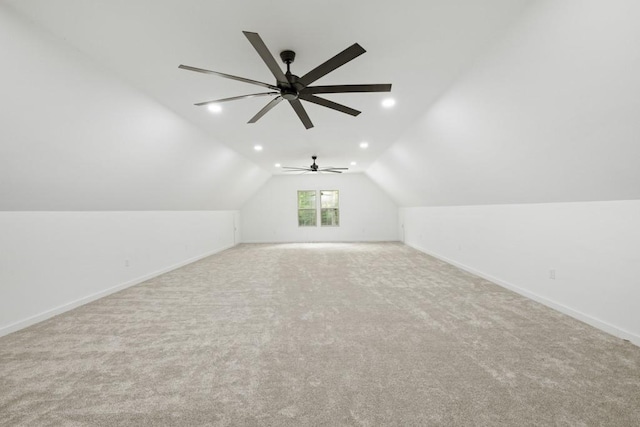 additional living space featuring lofted ceiling and light carpet