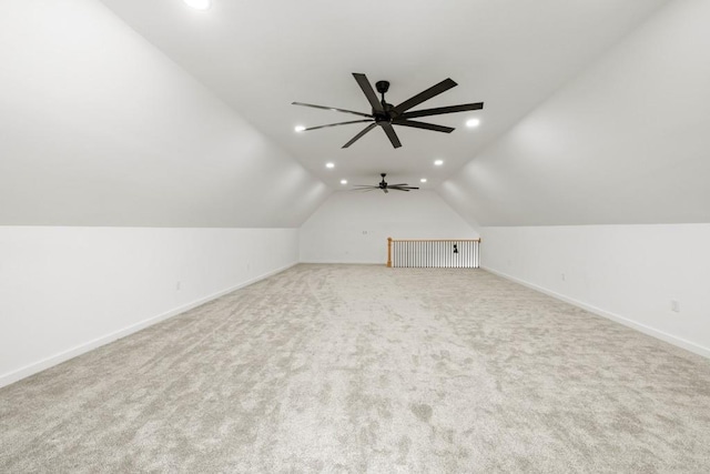 additional living space featuring vaulted ceiling and light carpet