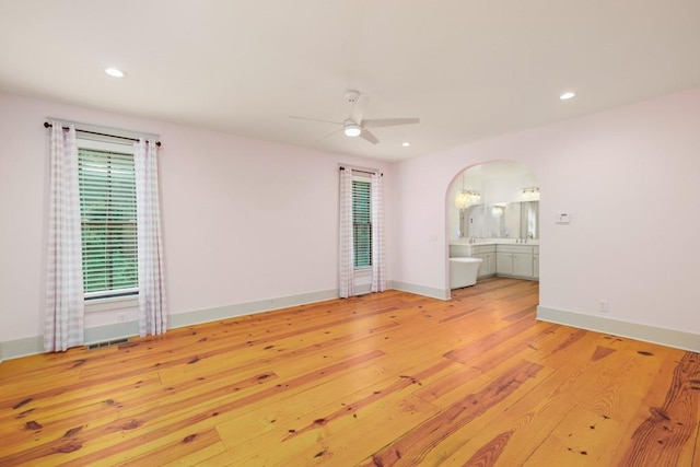 unfurnished room with ceiling fan and light wood-type flooring