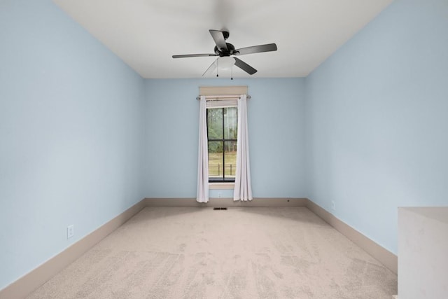 empty room featuring light colored carpet and ceiling fan