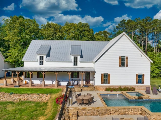 back of property featuring a swimming pool with hot tub, a yard, and a patio