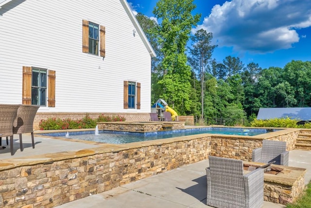 view of pool with a playground, a patio, and pool water feature