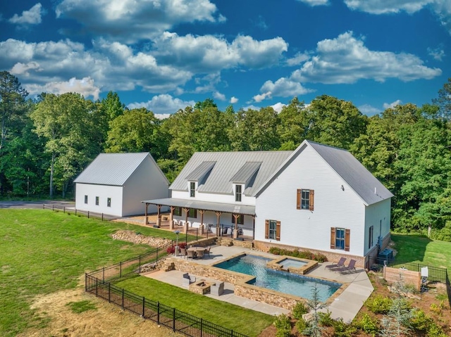 back of property featuring a swimming pool with hot tub, a yard, and a patio area