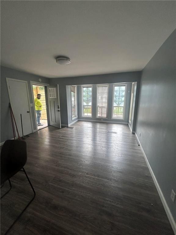 6072 Holiday Blvd, Forest Park, GA 30265 - unfurnished living room with baseboards and dark wood-style flooring
