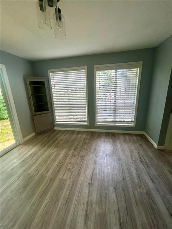 6072 Holiday Blvd, Forest Park, GA 30265 - unfurnished dining area featuring wood finished floors, baseboards, and plenty of natural light