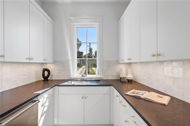 kitchen with stainless steel dishwasher, white cabinetry, and tasteful backsplash