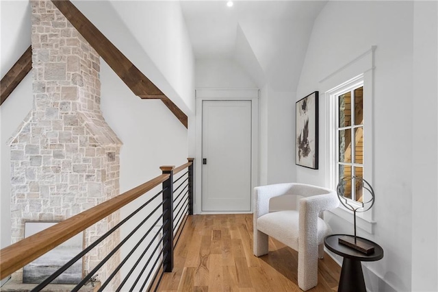 corridor featuring lofted ceiling with beams and light hardwood / wood-style flooring