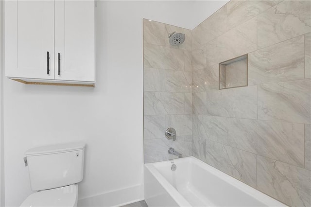 bathroom featuring toilet and tiled shower / bath