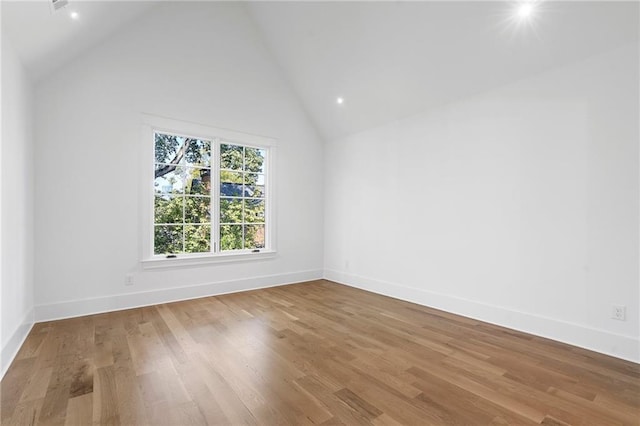 empty room with hardwood / wood-style floors and high vaulted ceiling