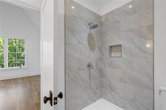 bathroom featuring wood-type flooring and tiled shower