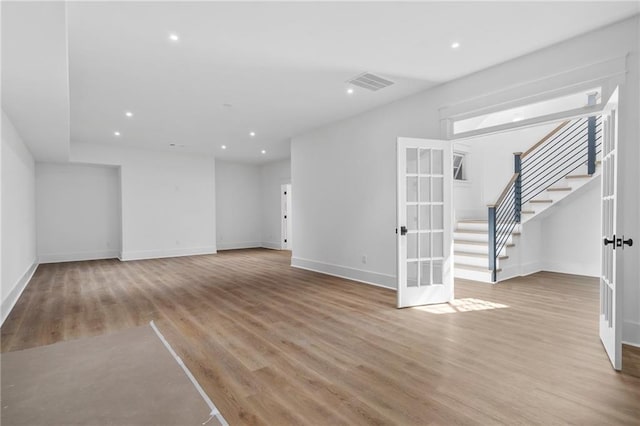 unfurnished living room featuring light hardwood / wood-style floors and french doors