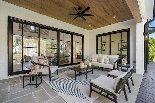 sunroom with ceiling fan and wooden ceiling