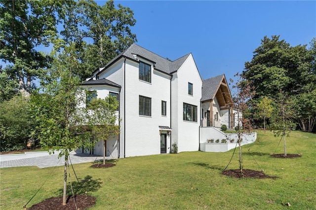 back of house featuring a lawn and a garage