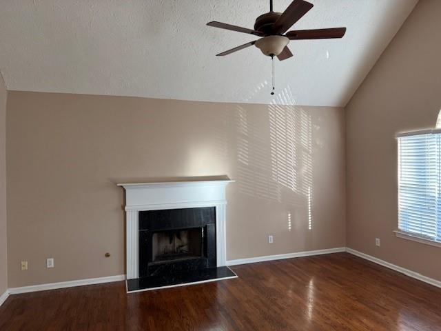 unfurnished living room featuring a textured ceiling, dark wood-type flooring, ceiling fan, and lofted ceiling