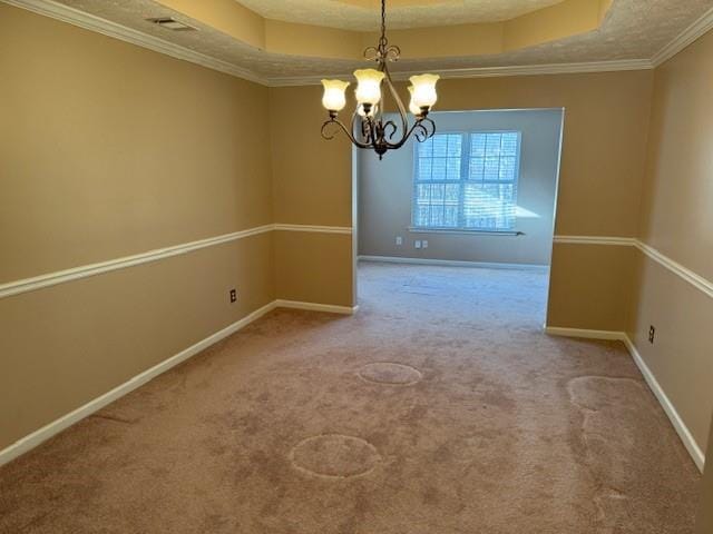 unfurnished dining area with a tray ceiling, carpet flooring, ornamental molding, and a notable chandelier