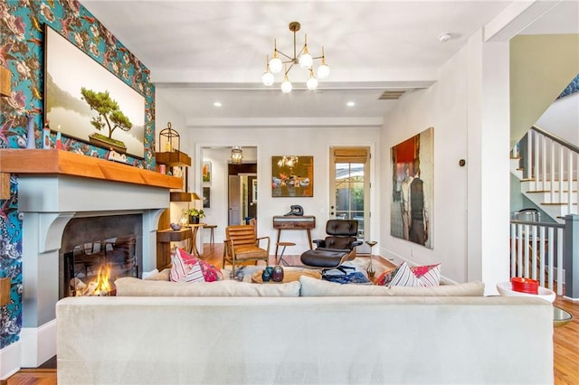 living room with beamed ceiling, light hardwood / wood-style floors, and an inviting chandelier