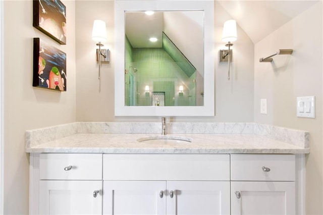 bathroom with vanity, a shower with shower door, and lofted ceiling