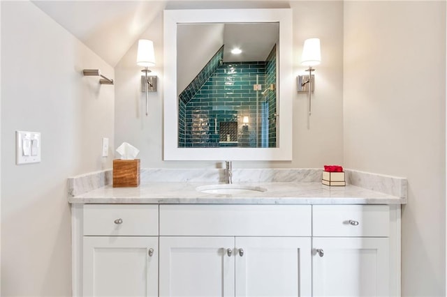 bathroom featuring vanity and lofted ceiling