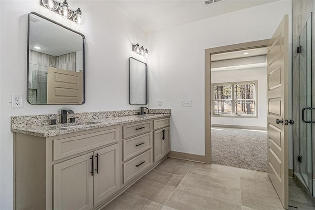 bathroom with vanity and a shower with door