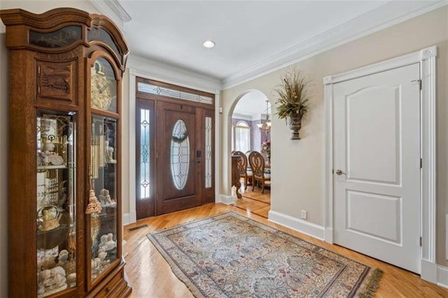 foyer with ornamental molding and light hardwood / wood-style flooring