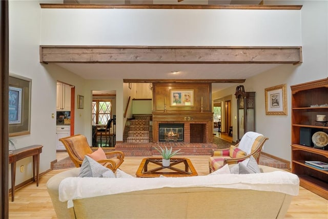 4820 Coppedge Trl, Peachtree Corners, GA 30096 - living area with light wood-type flooring, a brick fireplace, beamed ceiling, stairway, and baseboards