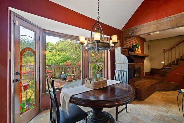 4820 Coppedge Trl, Peachtree Corners, GA 30096 - dining area featuring stone tile flooring, vaulted ceiling, a chandelier, stairway, and a fireplace