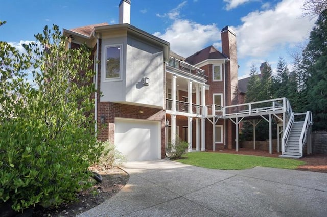 821 Camden Park Ct, Atlanta, GA 30342 - rear view of house with driveway, a balcony, stairs, brick siding, and an attached garage