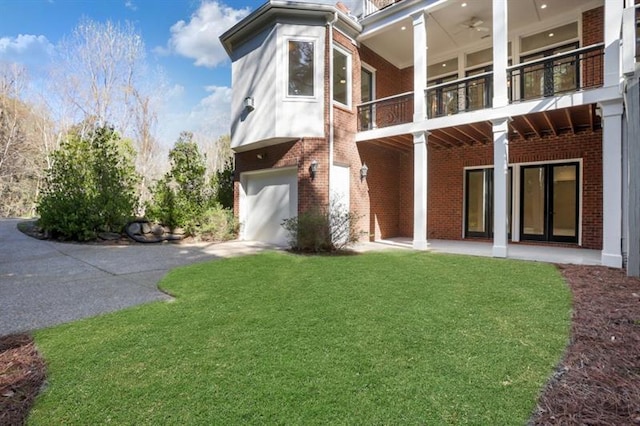 821 Camden Park Ct, Atlanta, GA 30342 - rear view of property with brick siding, a balcony, an attached garage, driveway, and a lawn