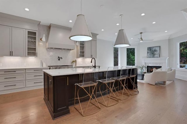 821 Camden Park Ct, Atlanta, GA 30342 - kitchen featuring premium range hood, light countertops, decorative backsplash, a kitchen bar, and recessed lighting