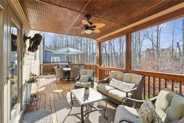 wooden terrace with ceiling fan and an outdoor hangout area