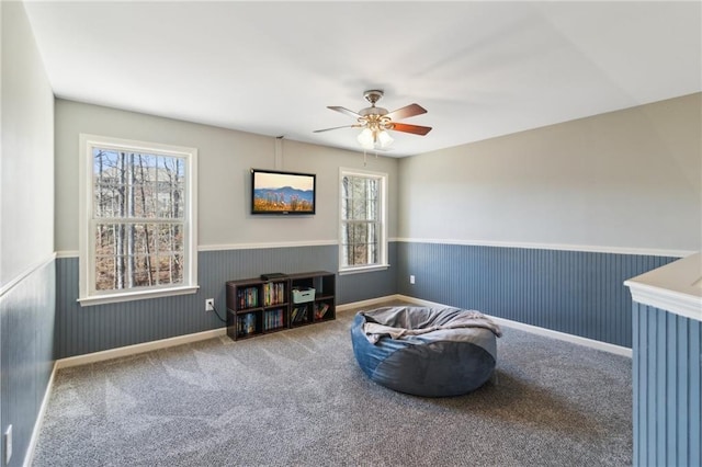 living area featuring ceiling fan and carpet