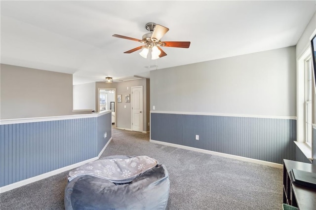 living area featuring carpet flooring and ceiling fan