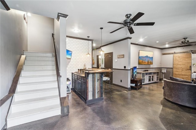 interior space featuring a breakfast bar area, hanging light fixtures, a center island, ceiling fan, and a barn door