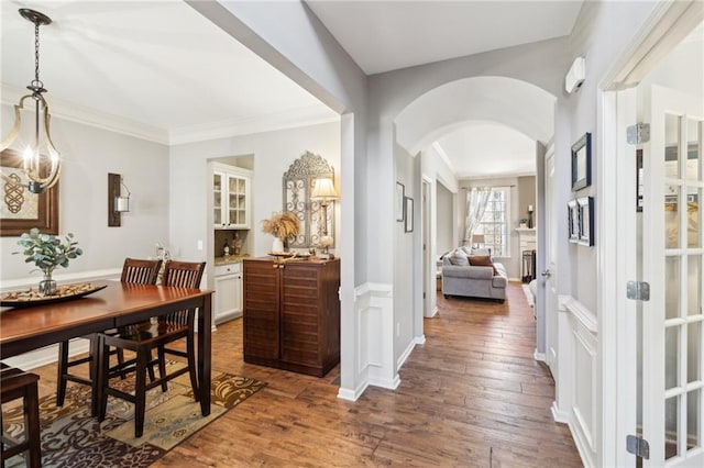 interior space featuring crown molding, an inviting chandelier, and dark hardwood / wood-style flooring