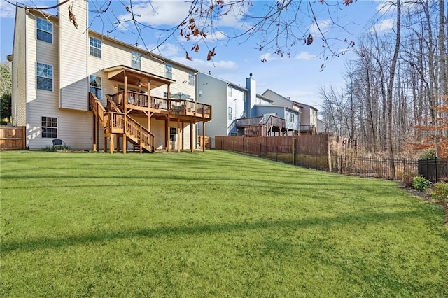 back of house featuring a wooden deck and a lawn