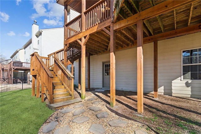 exterior space featuring a wooden deck and a lawn