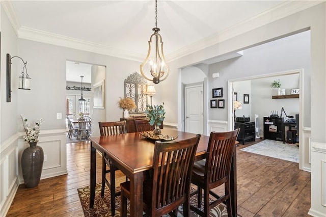 dining room featuring an inviting chandelier, crown molding, and dark wood-type flooring