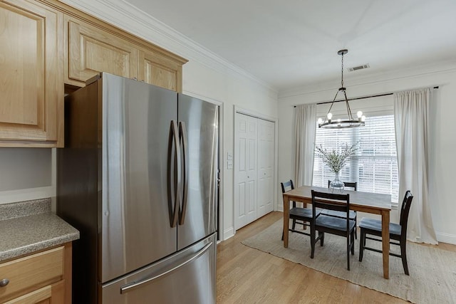 kitchen featuring light wood finished floors, visible vents, freestanding refrigerator, crown molding, and light brown cabinetry